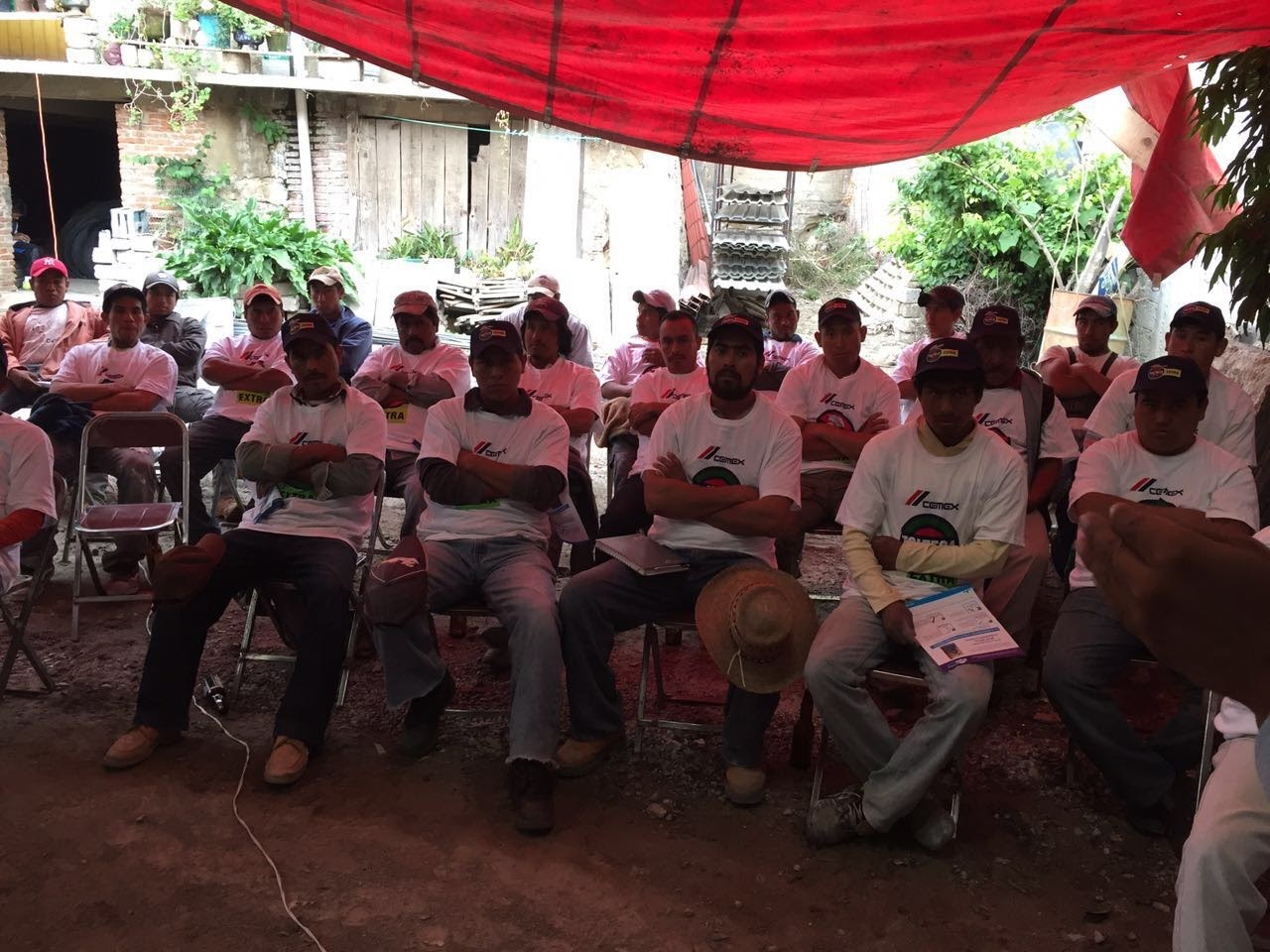 Asistentes sentados bajo una lona durante el taller de capacitación en Acatzingo, Puebla, 2016