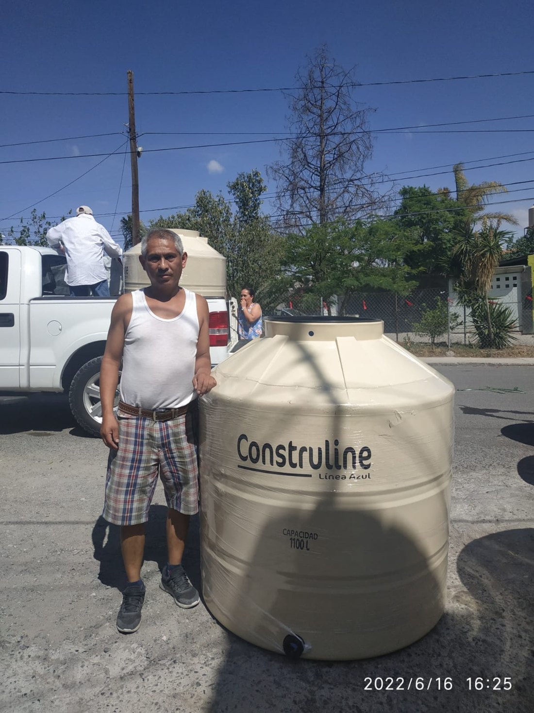 Beneficiario junto a un tinaco entregado en Colón, Querétaro, 2022