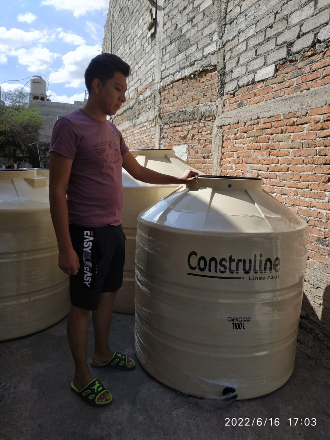 Beneficiario junto a un tinaco entregado en Colón, Querétaro, 2022